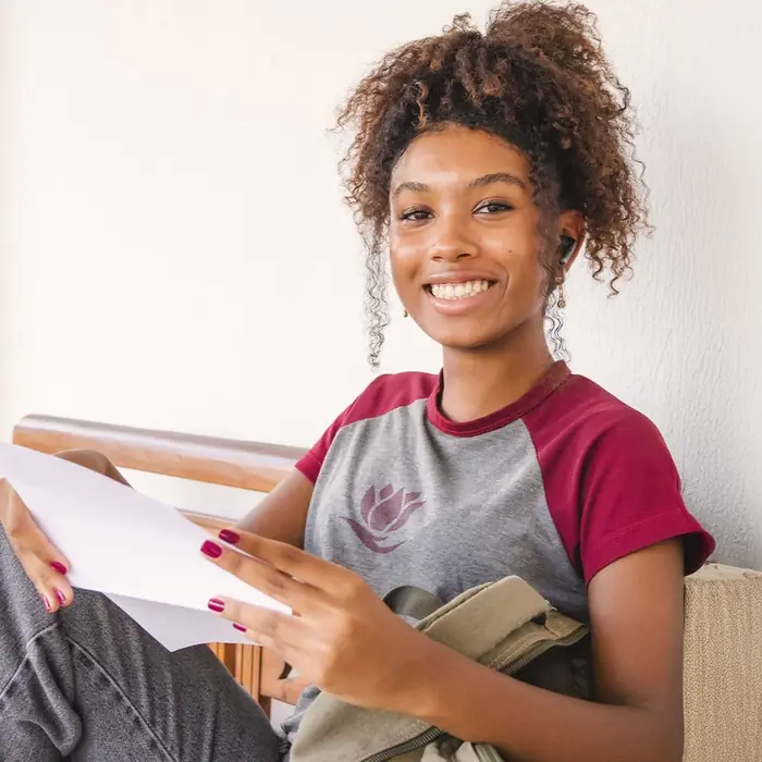 Aluna do Ensino Médio sorrindo com seu caderno